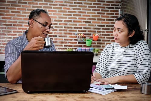 Photograph of a woman interviewing a man in a relaxed home setting